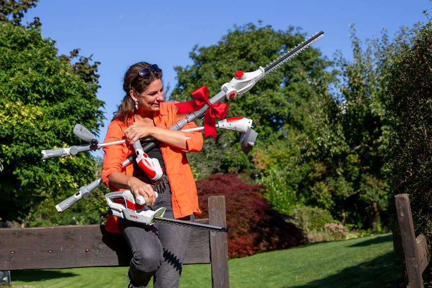 Eine Frau hält mit beiden Armen die vielen Geräte der 12 Volt Akku Linie fest.