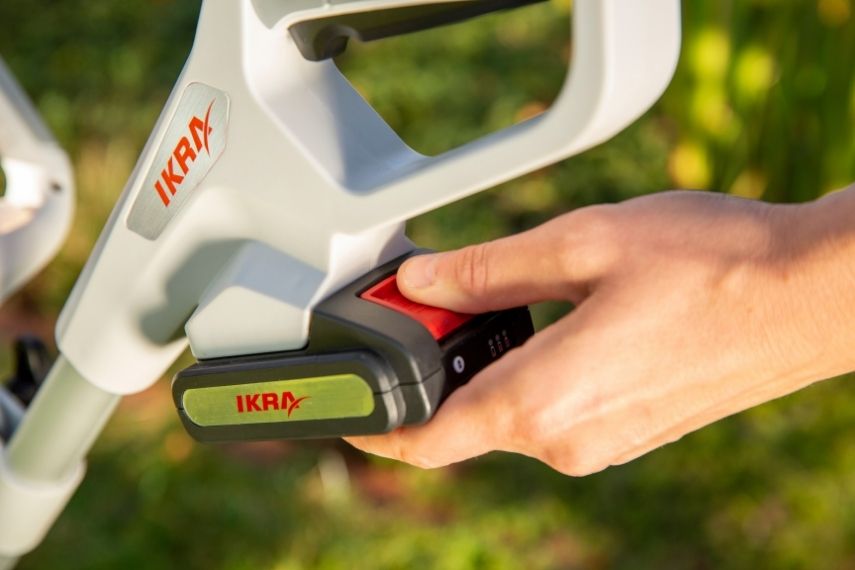 Ein 20 Volt Akku wird in ein passendes Gartengerät aus dem IKRA Sortiment eingesetzt.