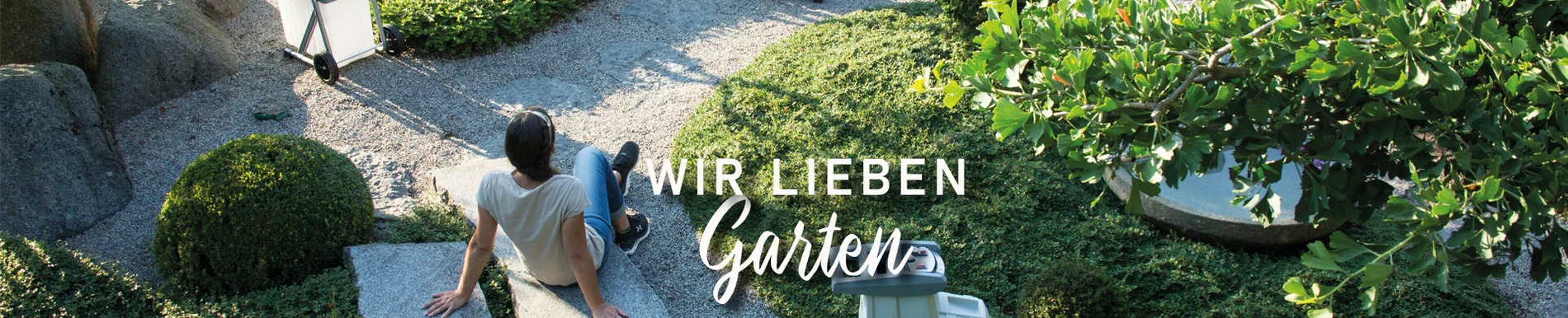 Das Bild zeigt eine Frau sitzend im Garten umgeben von Gartengeräten